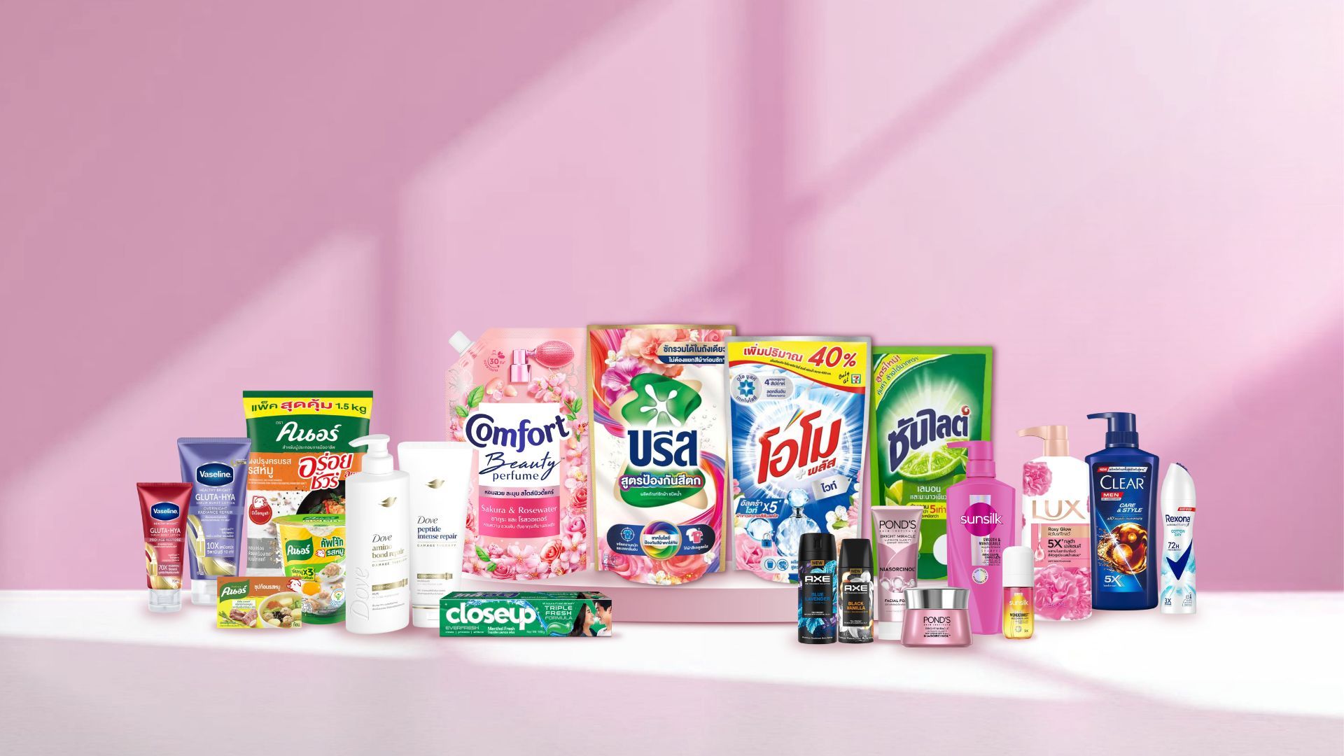 ผลิตภัณฑ์ดูแลส่วนบุคคลและของใช้ในครัวเรือนหลากหลายชนิด วางอยู่บนพื้นหลังสีชมพู