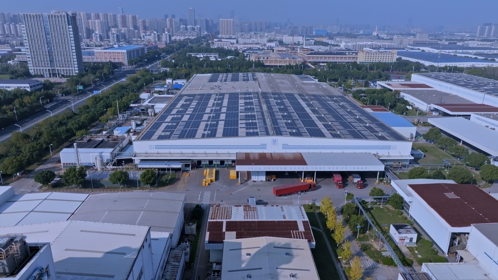 ภาพถ่ายโรงงานของยูนิลีเวอร์ในเมืองเหอเฟย ประเทศจีน ซึ่งมีการติดตั้งแผงโซลาร์เซลล์บนหลังคา โดยสามารถมองเห็นตัวเมืองได้ในฉากหลัง