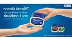 ภาพโฆษณาของวาสลีน แสดงถึงการส่งมอบวาสลีนผลิตภัณฑ์ เพียว รีแพร์ริ่ง เจลลี่ พร้อมข้อความ ทุกการซื้อคือการให้ สมทบทุนให้สภากาชาดไทย ร่วมบริจาค 1 บาท
