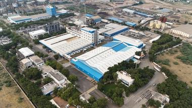 ภาพมุมสูงของโรงงานแกนธิดามของยูนิลีเวอร์ในอินเดีย โรงงานผลิตขนาดใหญ่ในโทนสีขาวและน้ำเงิน