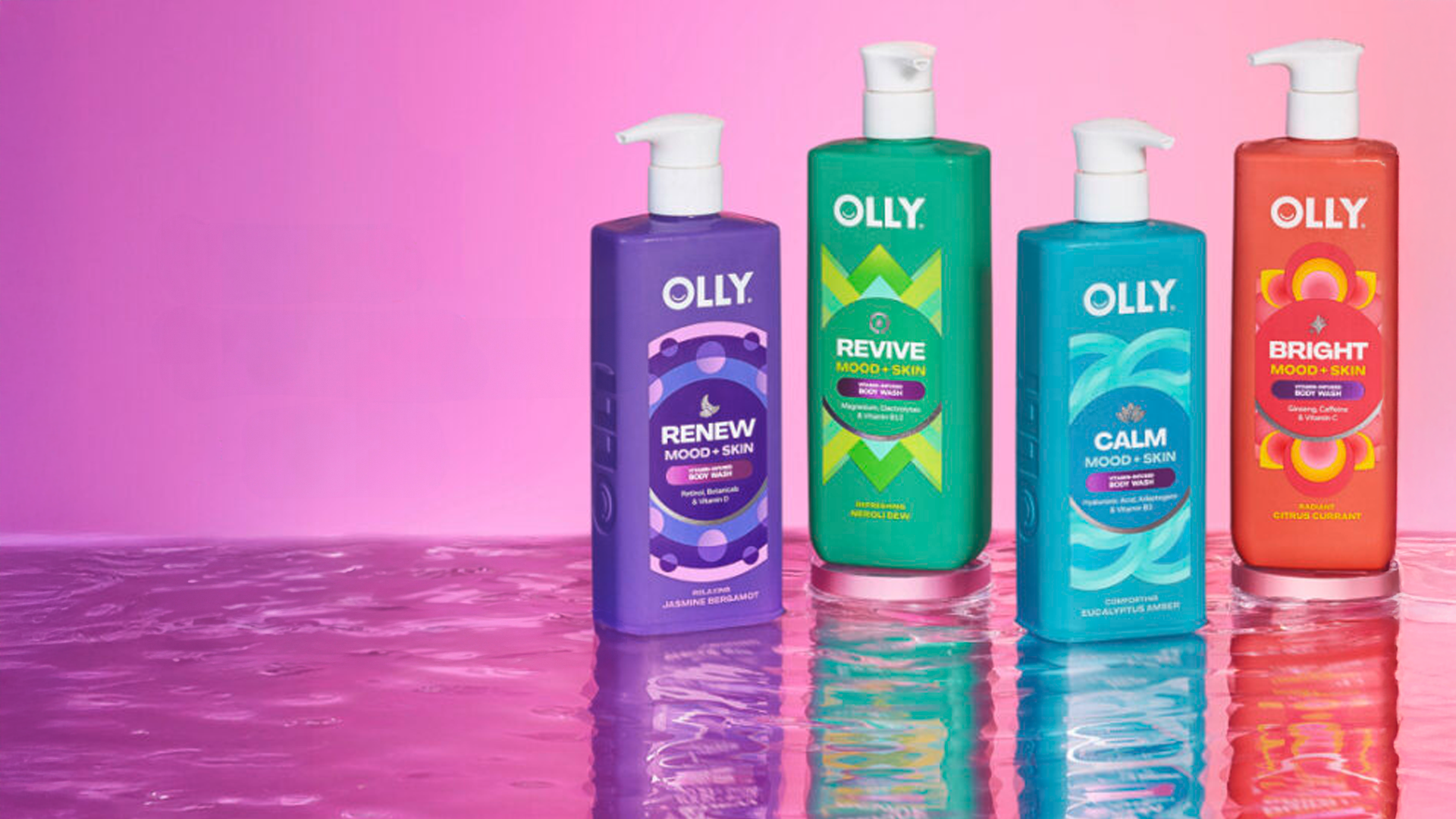 ขวดเจลอาบน้ำ Olly Mood + Skin ที่มีสีสันสดใส 4 ขวดวางอยู่บนพื้นผิวสะท้อนแสง โดยมีพื้นหลังสีชมพูไล่ระดับ